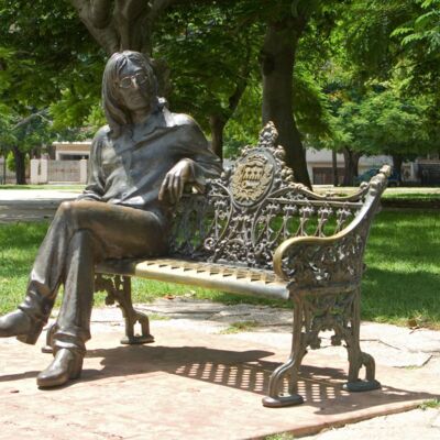 John Lennon lädt in einem kleinen Park in Havanna ein, neben ihm Platz zu nehmen.